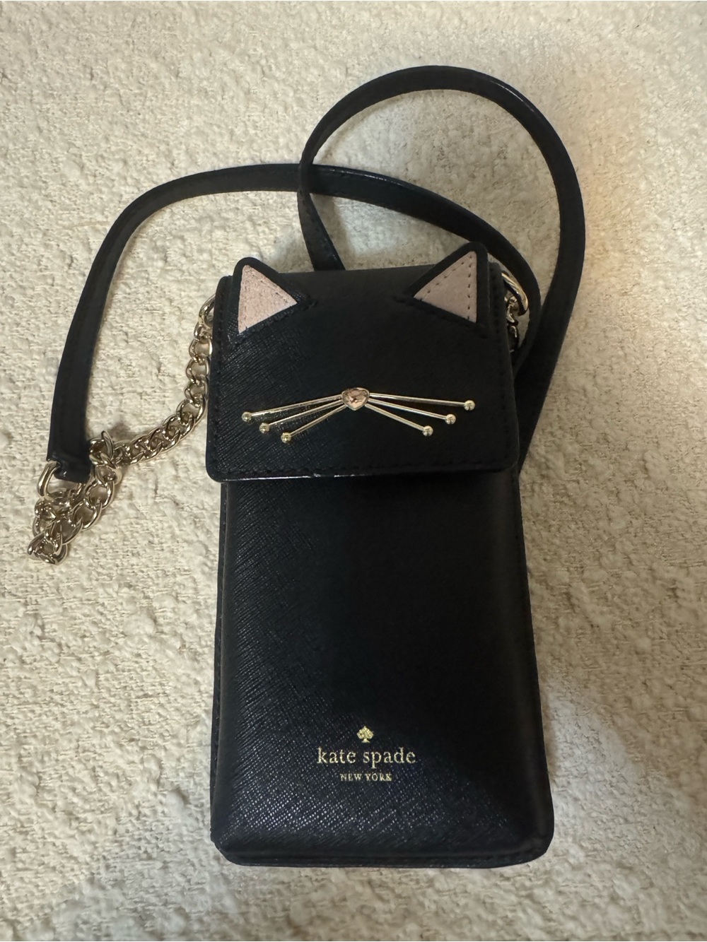 kate spade black crossbody phone bag with cat-ear flap and gold whisker detail